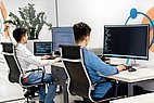Zwei Entwickler sitzen vor zwei PCs.