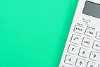 White calculator on green surface