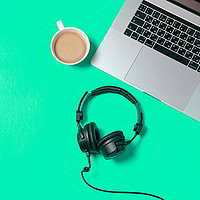 Laptop mit Cafe und Kopfhörer auf grünem Hintergrund.