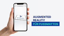 Hand probiert Augmented Reality bei Fußmatte.