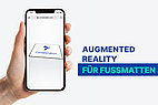 Hand probiert Augmented Reality bei Fußmatte.