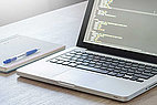 Laptop mit Programmiercode auf einem Tisch