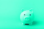 Green piggy bank on green background