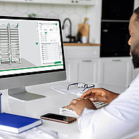 Person konfiguriert medizinisches Regalsystem am Computer.