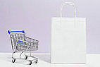 Blue shopping cart next to white bag.