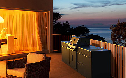 Outdoorküche auf einer Terasse und im Hintergrund ist ein Sonnenuntergang