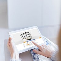 A woman operates an office space configurator on a tablet in a hall.