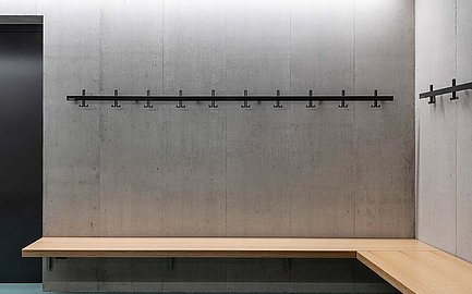 MAKK Wandgarderobe vor einer grauen Betonwand.