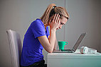 Woman with blue shirt supports her head