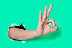 Hand shows the OK sign on green background