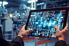 Man holding a tablet in a production hall.