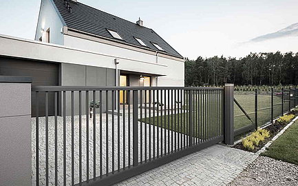 Graues Schiebetor vor Einfamilienhaus
