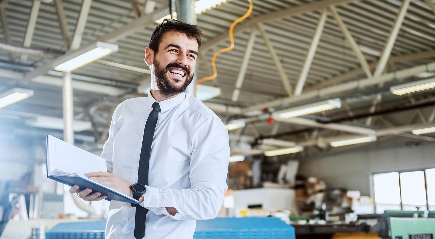 Mann mit Notizbuch in Industriehalle