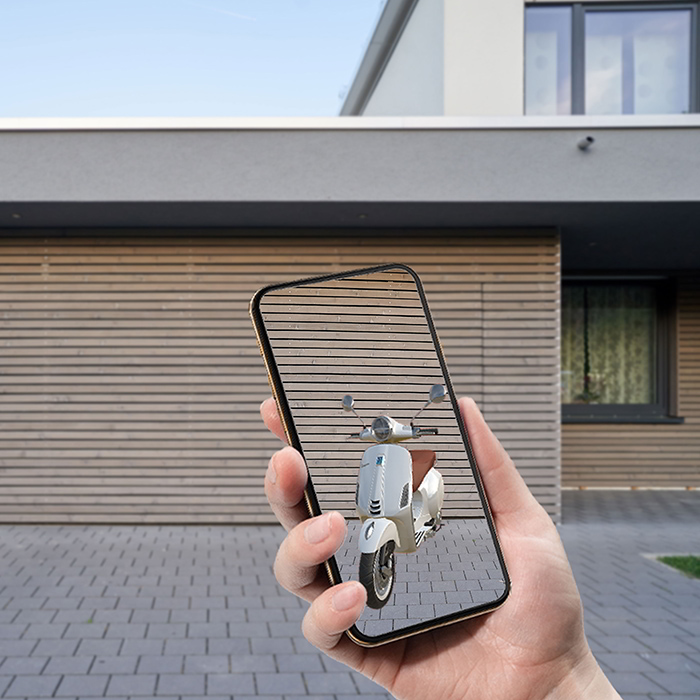 Smartphone zeigt mit Hilfe von Augmented Reality eine Vespa vor dem Haus