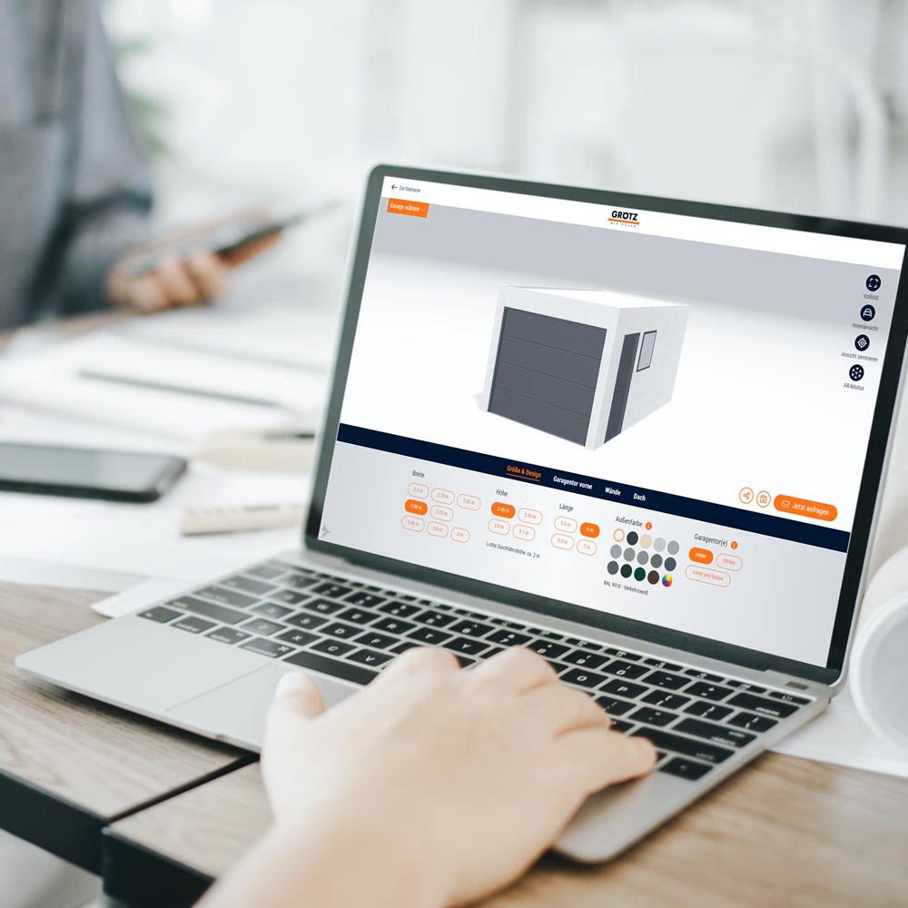 Eine Person bedient an einem Laptop den Grötz-Garagen-Konfigurator.