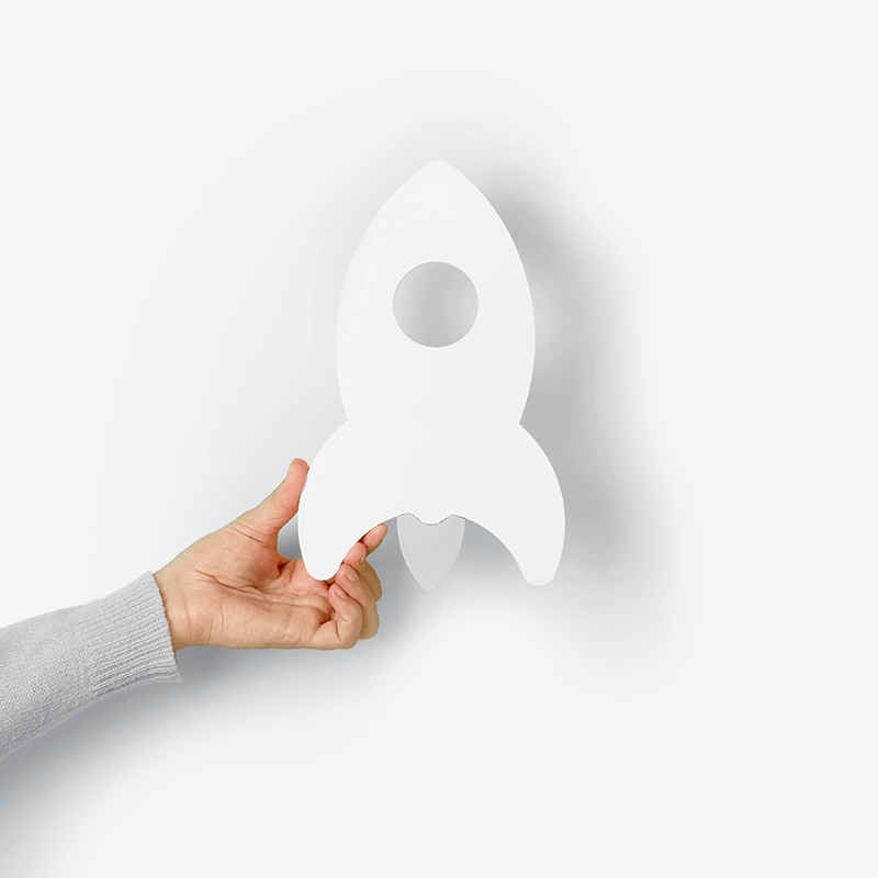 Hand holding a paper rocket.