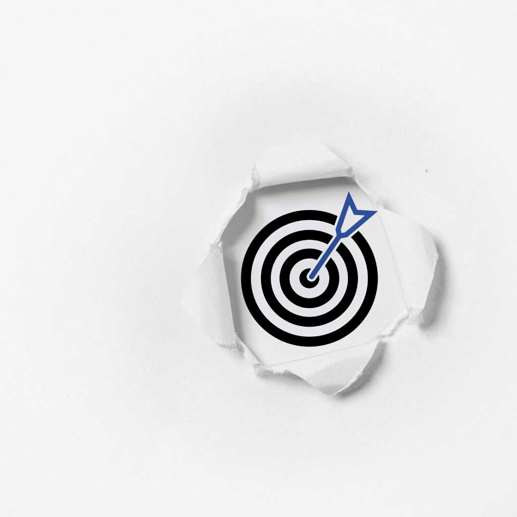 A target with an arrow in the center, visible through a torn piece of paper.